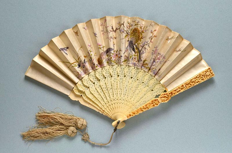 A Chinese ivory folding fan with double paper leaf and ornately carved guardstick made for export in China in 1870.