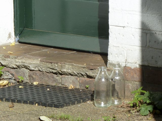 Picture of milk bottles behind a door in Hampstead Heath.